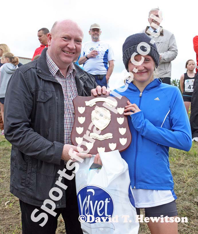 Look North weatherman Paul Mooney presents womens winner Michelle Holt (Sunderland Harriers) with the Prudhoe Miners Race Trophy.